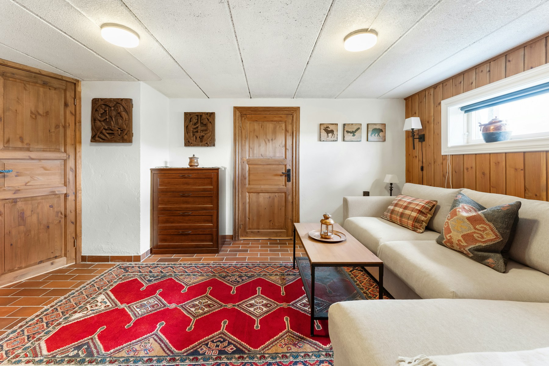 Rich red patterned rug in a warm wood-panelled living room